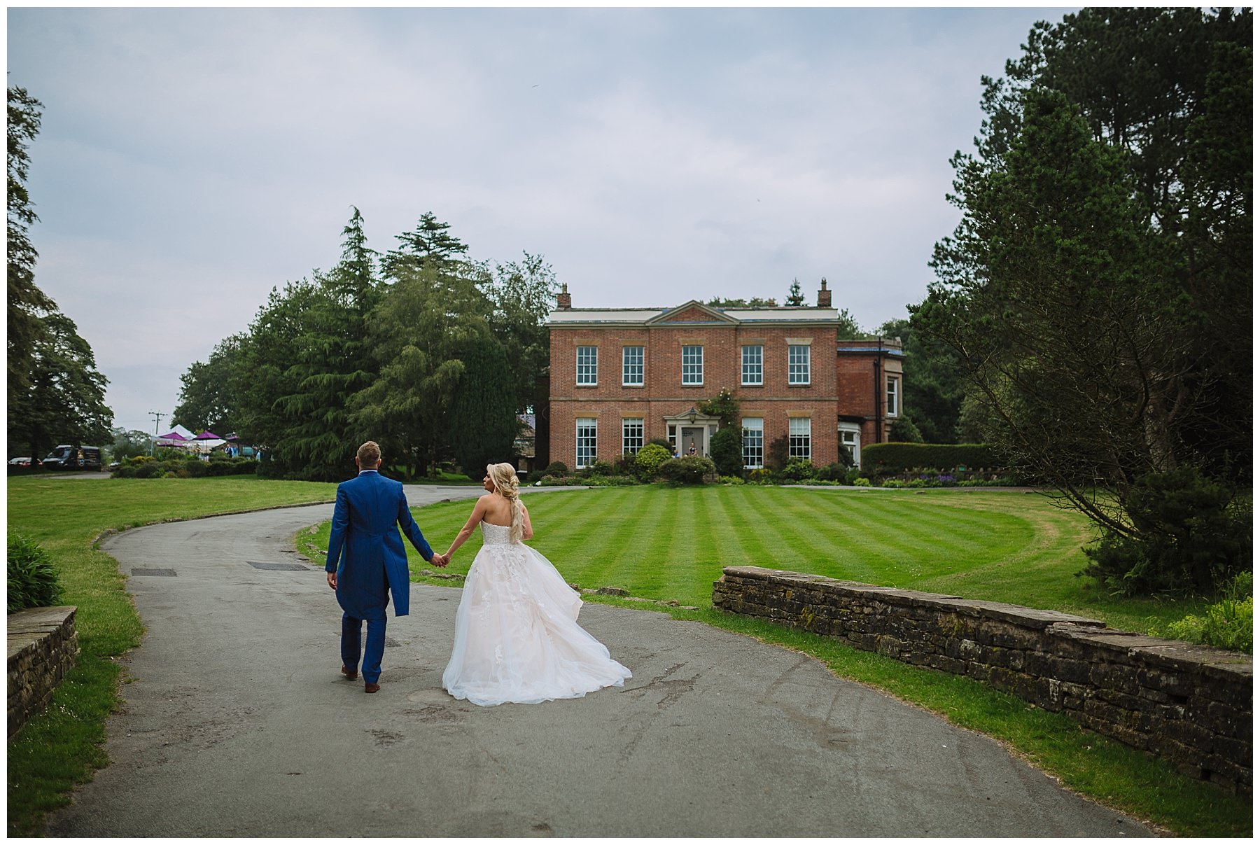 bride and groom walk hand in hand through the grounds at rivington barn