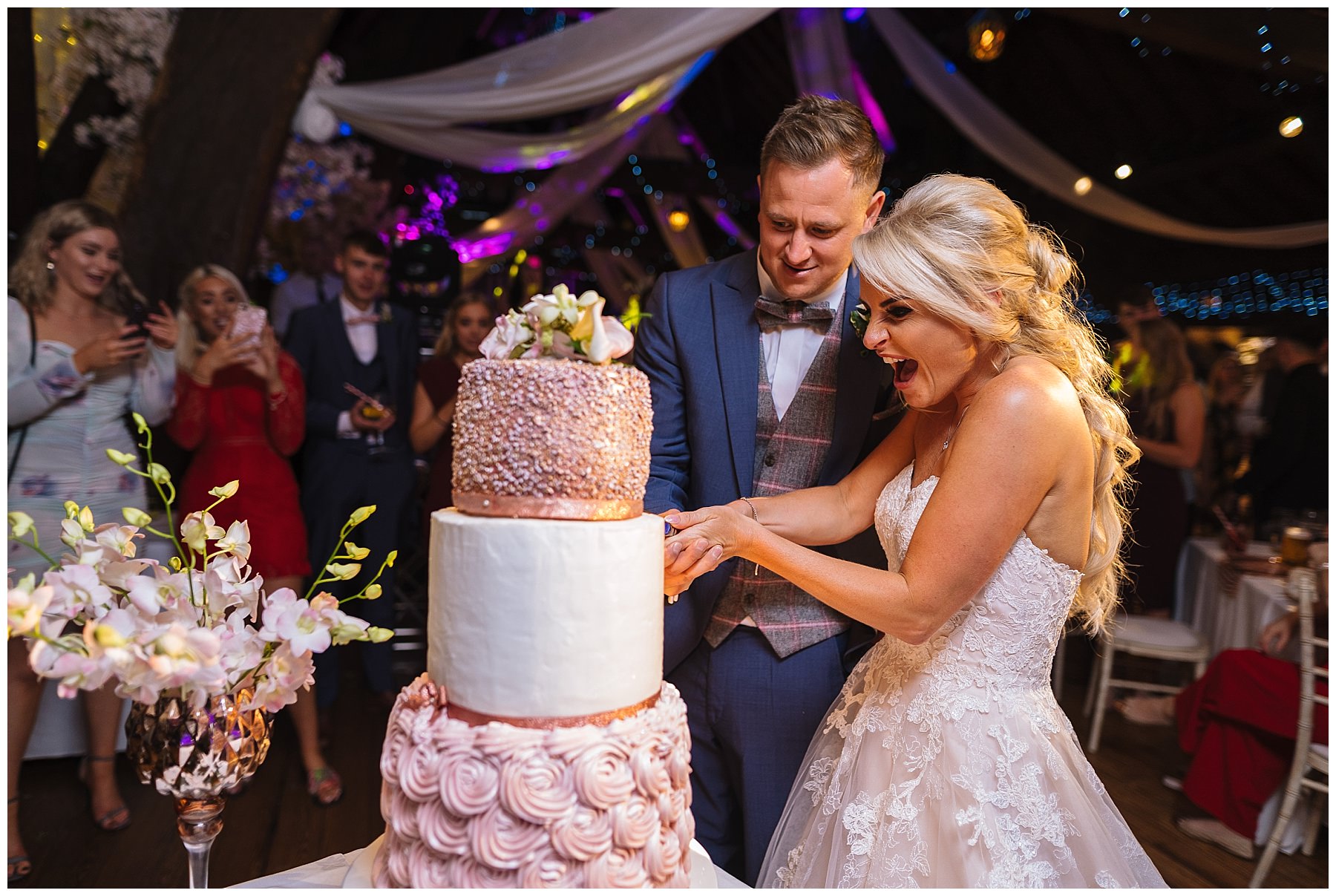 Amazing three tier wedding cake is cut by bride and groom at rivington barn wedding