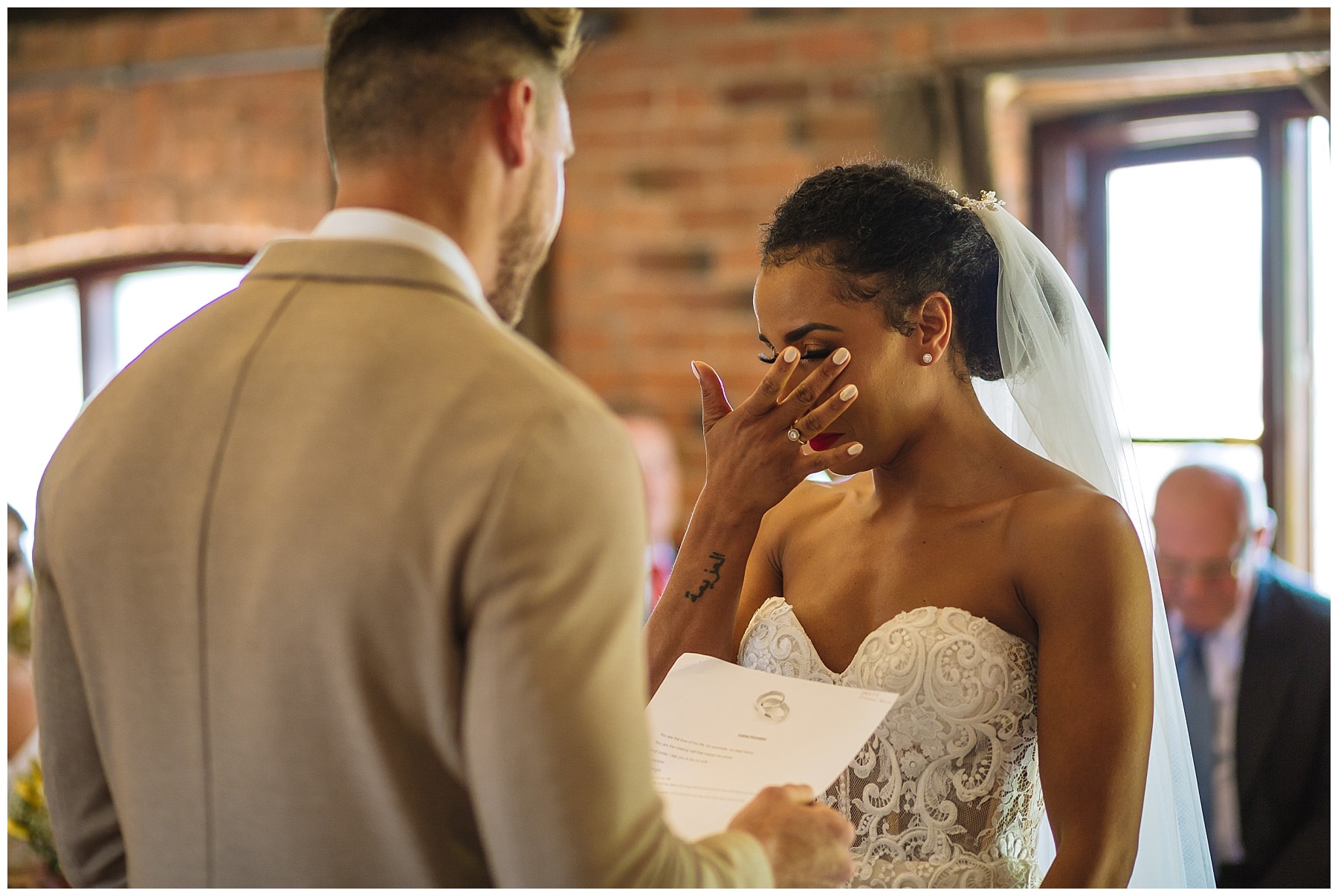 bride wipes away a tear during swancar farm wedding ceremony