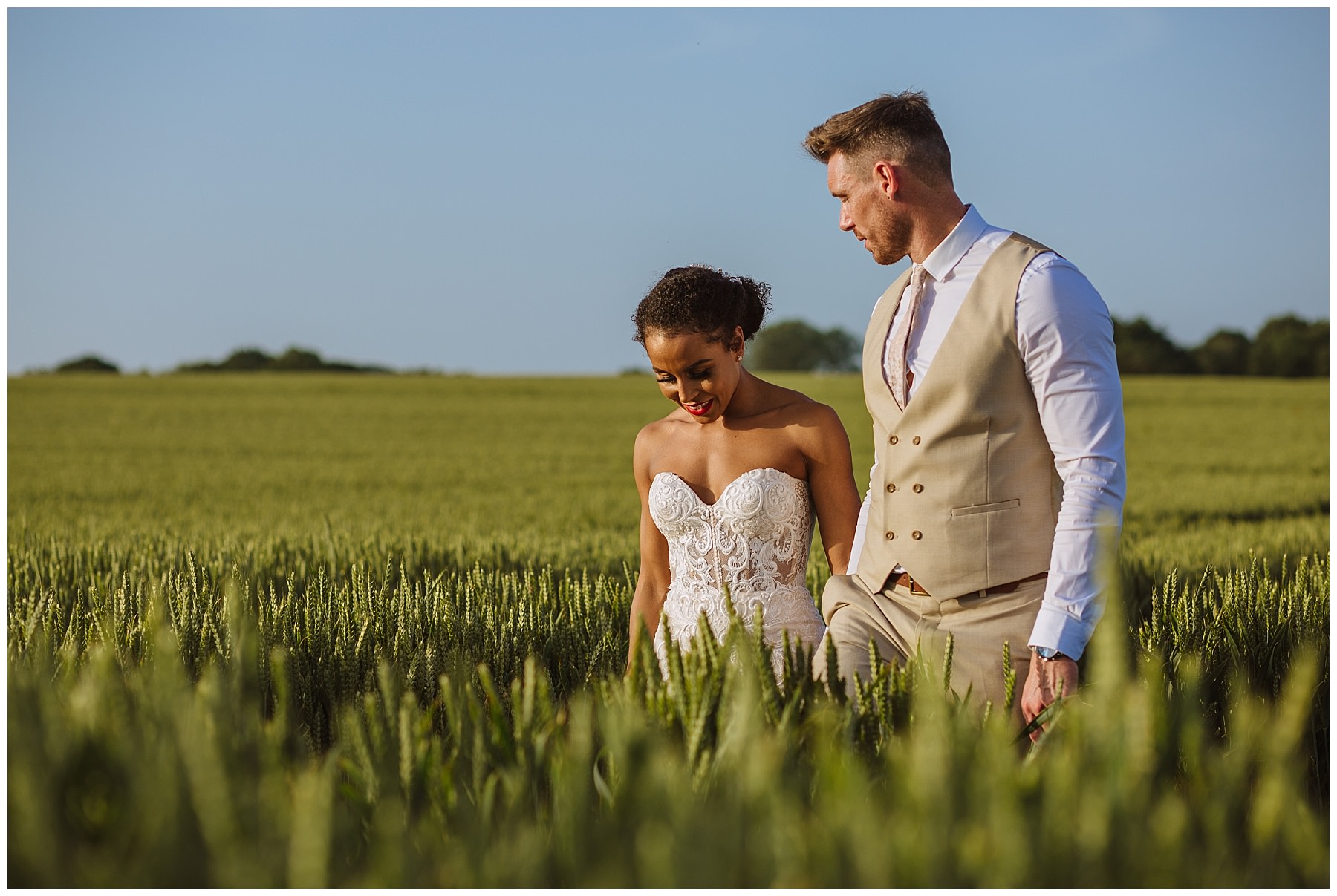 married couple walk through the fields at swancar farm