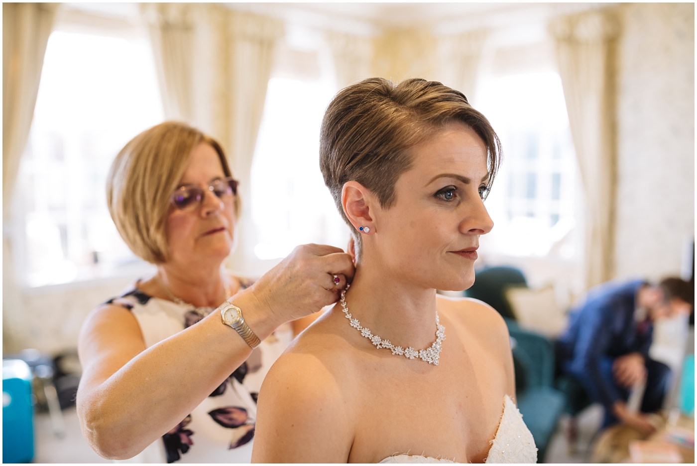 Mother of the bride assists with wedding jewellery