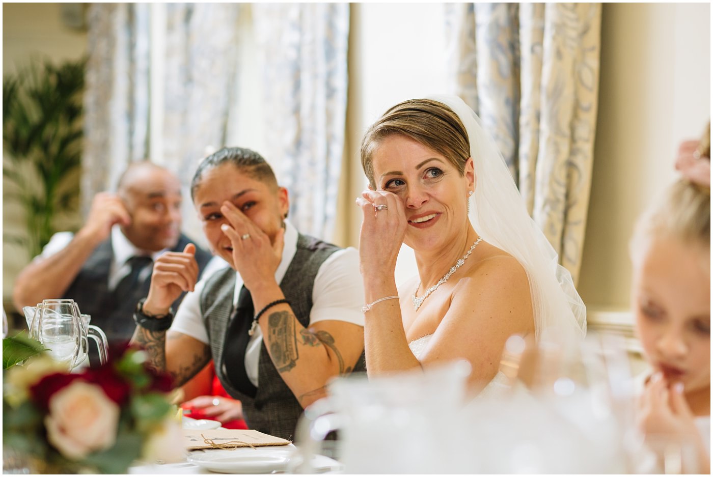 Bride wipes a tear from her eye during Eaves Hall wedding speech