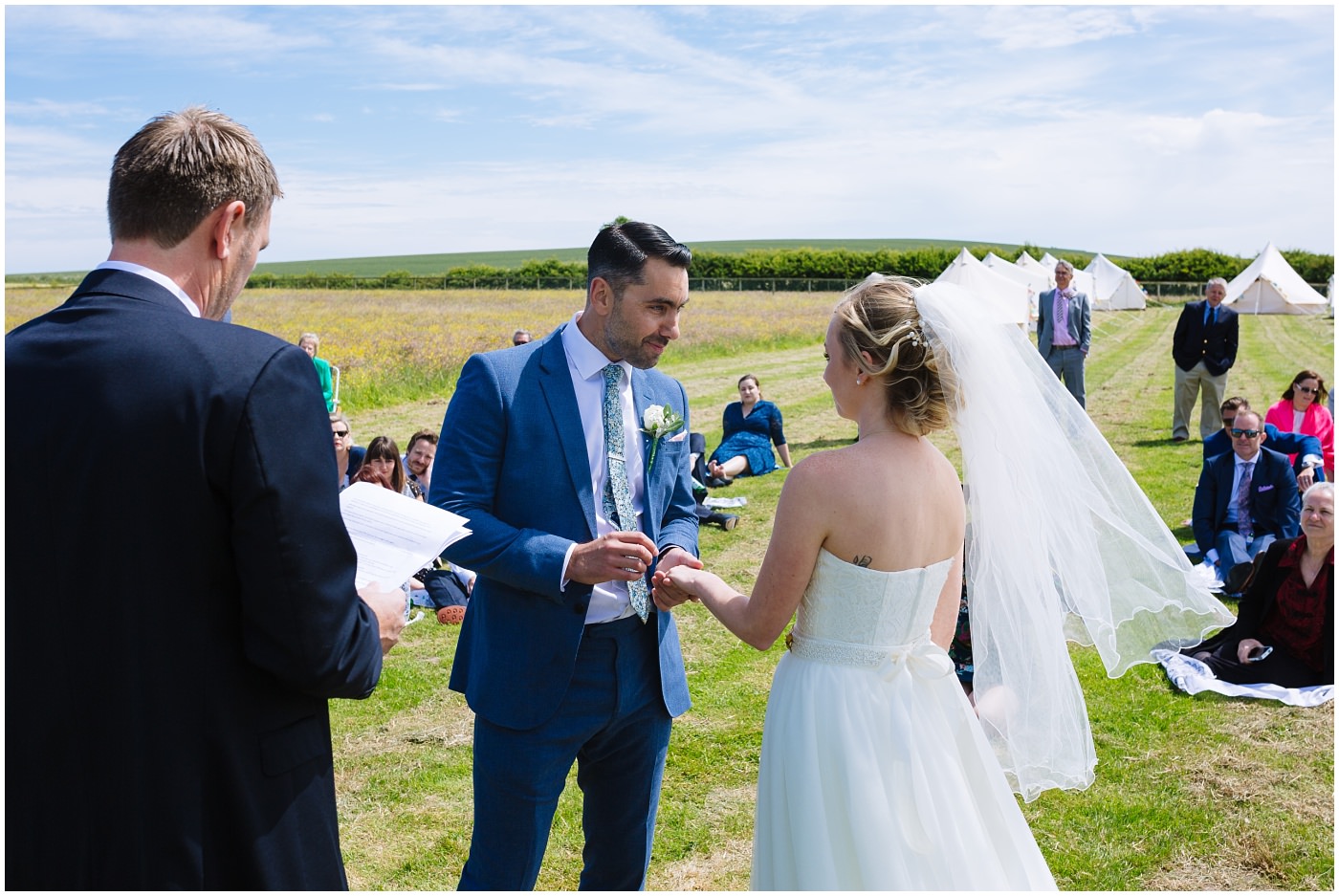 bride and groom exchange rings at wildwood and eden wedding outdoor ceremony