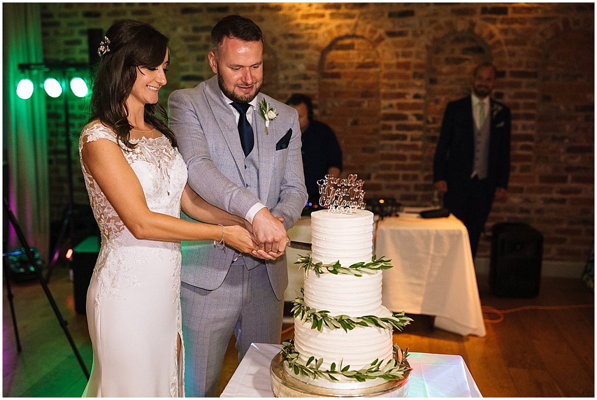 couple cut the wedding cake at arley hall