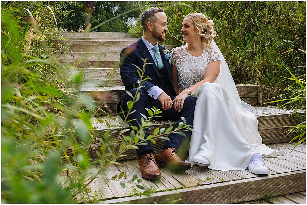 wedding couple take a moment down by the lakeside at styal lodge