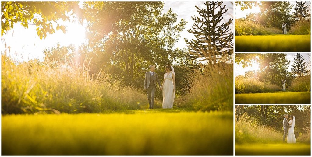 A bride and groom stroll together in a lush garden, surrounded by greenery and bathed in warm sunlight, capturing a moment of joy and intimacy at cheshires abbeywood estate